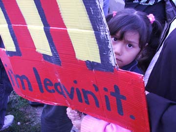 child holds sign protesting McDonalds